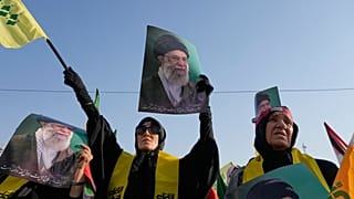 يتظاهر محتجون وهم يحملون ملصقات للمرشد الإيراني الأعلى، آية الله علي خامنئي، (تصوير: فاهيد سالمّي / أسوشيتد برس)