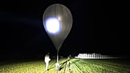 In this undated photo released by the State Border Guard Service an officer inspects a balloon used to carry cigarettes into Lithuania