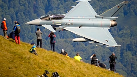 Entuzjaści lotnictwa obserwują przelot samolotu Eurofighter Typhoon Niemieckich Sił Powietrznych podczas pokazu lotnictwa wojskowego i akrobacyjnego, 26 sierpnia 2025 r.