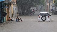 Niños juegan en una calle inundada por las lluvias provocadas por la tormenta tropical Melissa en Santo Domingo, República Dominicana, el viernes 24 de octubre de 2025.