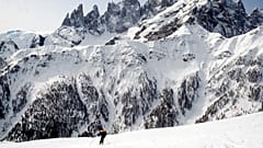 Con los Dolomitas nevados de fondo, un esquiador desciende a toda velocidad por una pista en Falcade, Italia. (AP Photo/Armando Trovati)