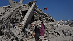 ARQUIVO: Mulheres palestinianas deslocadas inspeccionam os escombros de um edifício quando regressam a uma área em Khan Younis, no sul da Faixa de Gaza, sábado, 11 de outubro de 2025