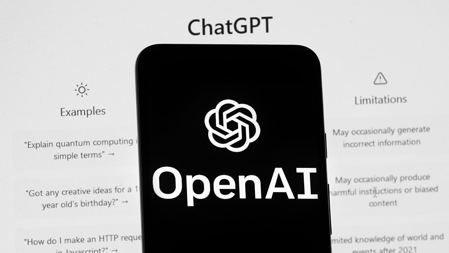 FILE - The OpenAI logo is seen on a mobile phone in front of a computer screen which displays the ChatGPT home Screen, on March 17, 2023, in Boston.