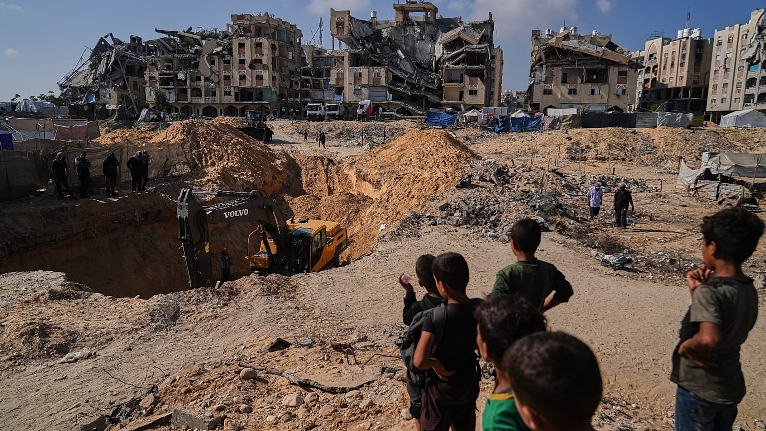 Des Palestiniens assistent aux recherches menées par des équipes et des engins égyptiens pour retrouver les corps des otages dans le quartier de Hamad City, à Khan Younès.