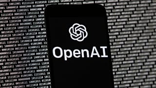 FILE. The OpenAI logo appears on a mobile phone in front of a computer screen with random binary data. Boston. 9 March 2023. 