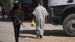 يقف أعضاء من كتائب القسام، الجناح العسكري لحركة حماس، في الموقع حيث يبحثون، عن جثث الرهائن في النصيرات، قطاع غزة، الثلاثاء 28 أكتوبر/تشرين الأول 2025 .