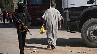 يقف أعضاء من كتائب القسام، الجناح العسكري لحركة حماس، في الموقع حيث يبحثون، عن جثث الرهائن في النصيرات، قطاع غزة، الثلاثاء 28 أكتوبر/تشرين الأول 2025 .