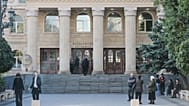 Lyanne Kennedy, background left, stands at an entrance as she arrives to attend the court session in Tbilisi, Georgia, Tuesday, Oct. 28, 2025.