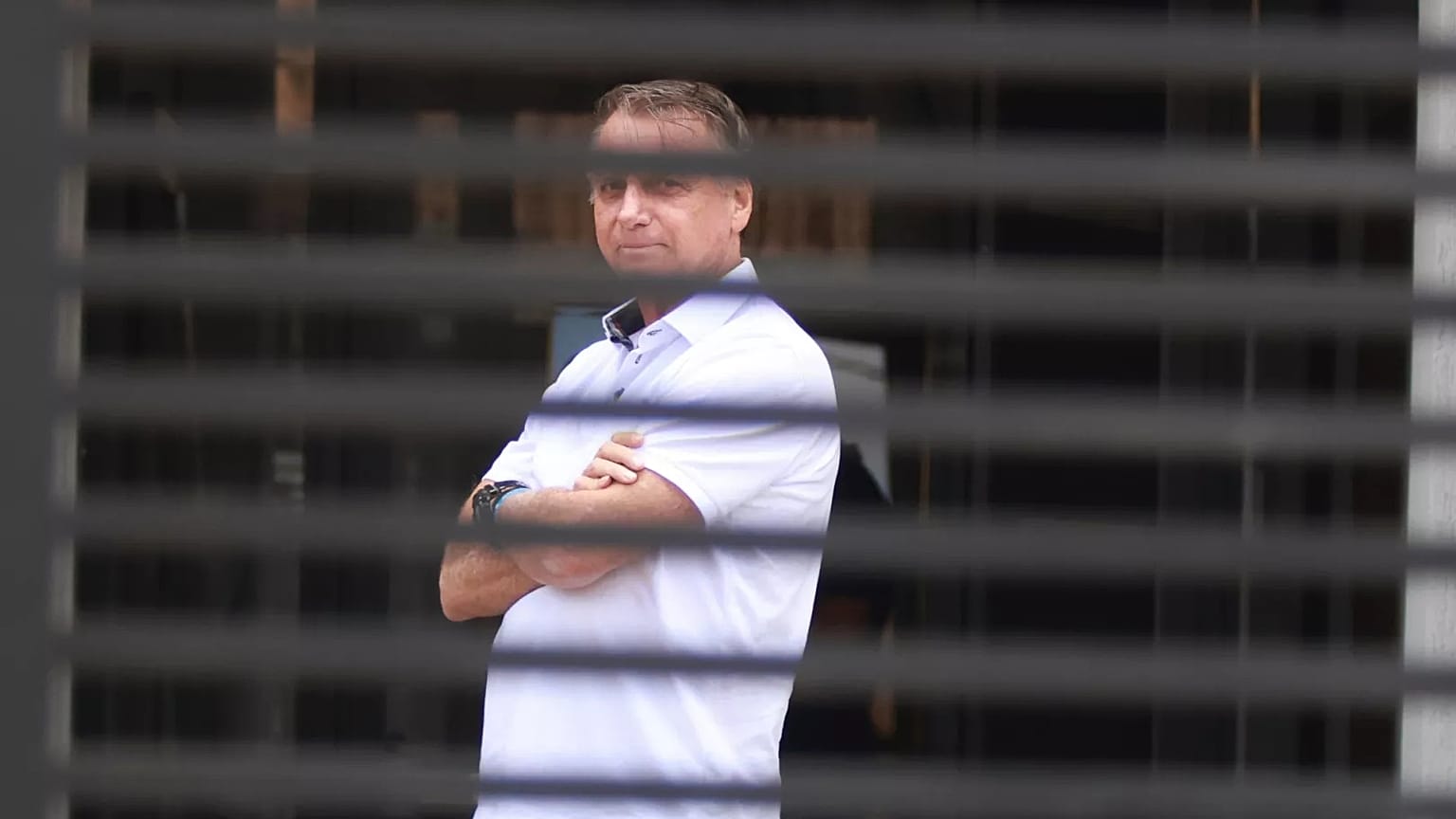 Brazil's former President Jair Bolsonaro stands at the entrance of his home where he is under house arrest in Brasilia, 2 September, 2025
