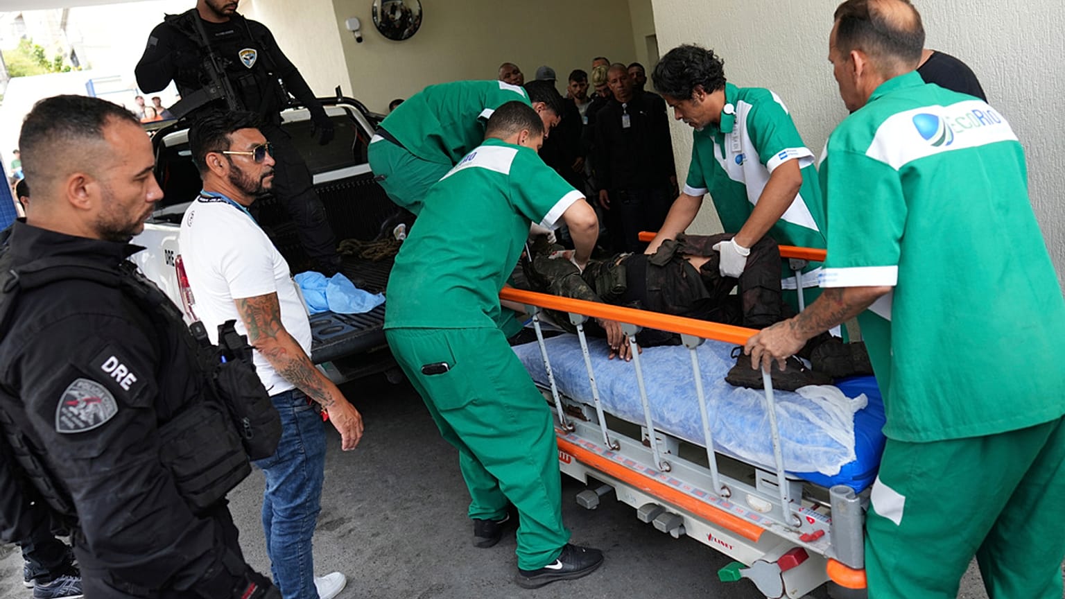 Funcionários do Hospital Getúlio Vargas transportam uma pessoa ferida numa maca depois de ela ter sido levada numa viatura policial ao hospital durante uma operação policial