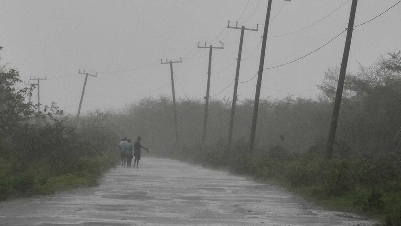 People walk along a road during the passing of Hurricane Melissa in Rocky Point, Jamaica, Tuesday, Oct. 28,