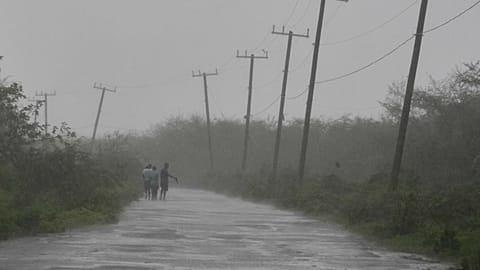 Des personnes marchent le long d'une route pendant le passage de l'ouragan Melissa à Rocky Point, en Jamaïque, le mardi 28 octobre 2025