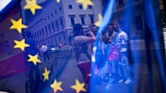 En esta foto del viernes 24 de junio de 2016, se ve a un grupo de turistas posando para una fotografía frente al Parlamento a través de la bandera de la UE en Madrid, España.