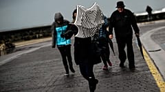 ARCHIVO: Una mujer intenta protegerse de la lluvia y el fuerte viento con su paraguas en San Sebastián, España, el 5 de febrero de 2017.