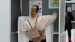 Μια γυναίκα στέκεται σε ένα εκλογικό τμήμα με ένα φύλλο που περιέχει όλους τους υποψηφίους κατά τη διάρκεια των γενικών εκλογών στη Χάγη, Ολλανδία, Τετάρτη 29 Οκτωβρίου 2025. 