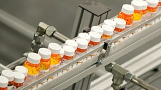 Frascos de medicamentos se desplazan sobre una cinta transportadora en un almacén de farmacia de venta por correo en Florence, Nueva Jersey, el 10 de julio de 2018.