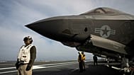 ARQUIVO - Marinheiros da Marinha dos EUA ao lado de um caça F-35 no convés de um porta-aviões, 30 de maio de 2024.