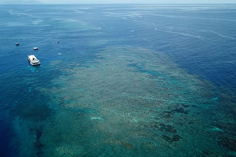 A boat sits above a section of the Great Barrier Reef off coast of Queensland, 14 November, 2022
