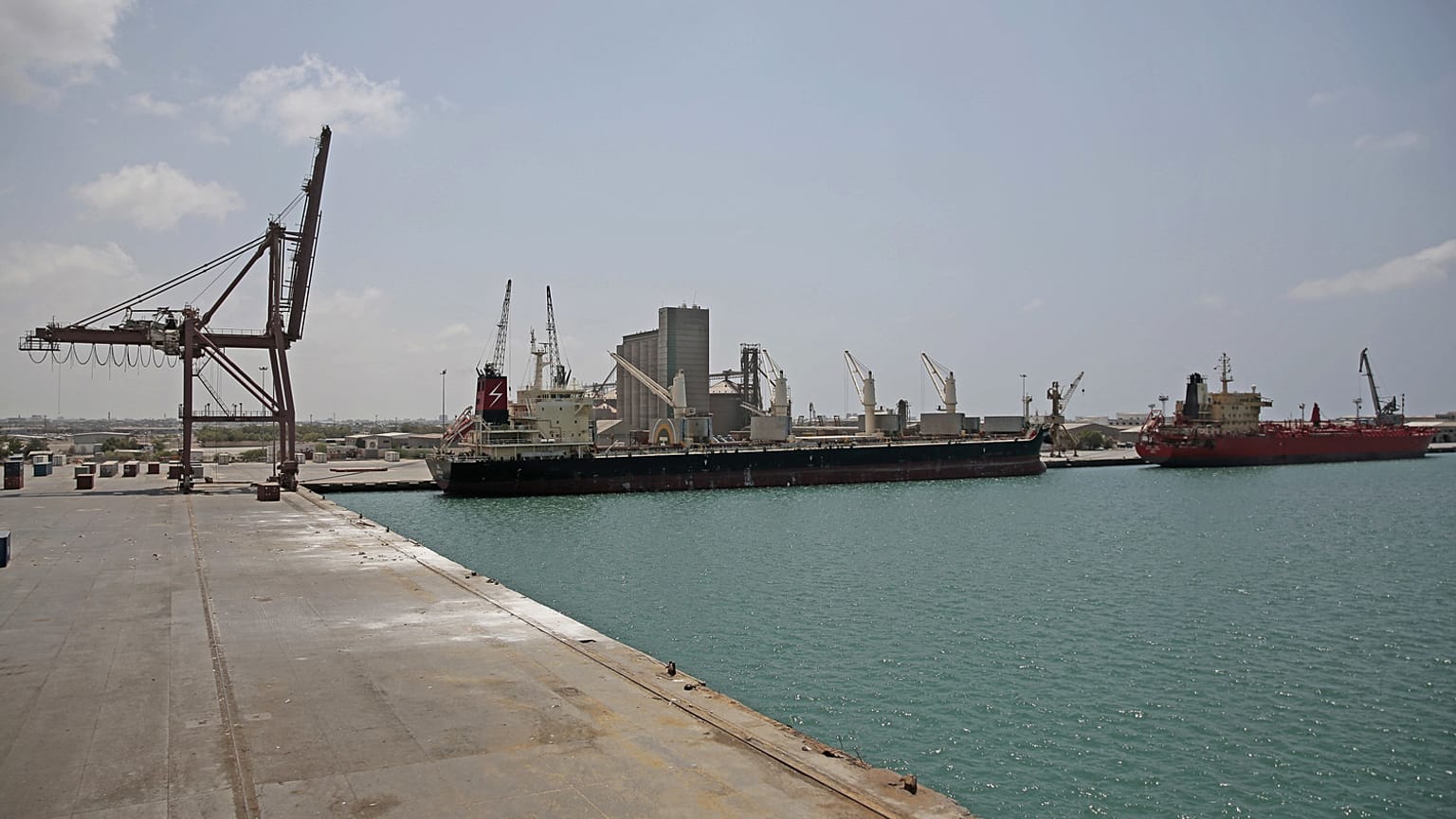 سفينة شحن وناقلة نفط متوقفتين أثناء رسوّهما في ميناء