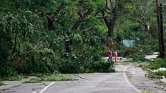 Menschen gehen eine Straße entlang. Zuvor war Hurrikan Melissa über Spurr Tree auf Jamaika hinweggezogen.