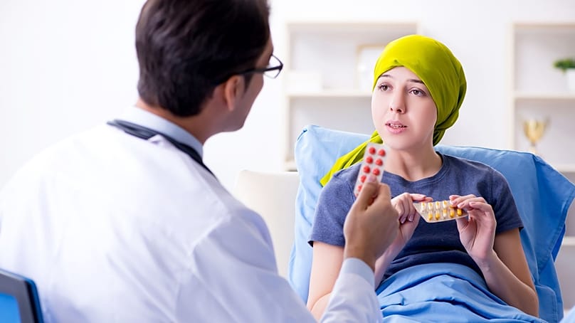 طبيب يتحدث مع مريضة تتلقى علاجاً للسرطان