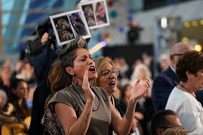 Familiares das vítimas reagem durante uma cerimónia em memória das inundações que mataram mais de 230 pessoas, em Valência, a 29 de outubro de 2025.