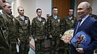 President Vladimir Putin holds Russian Orthodox icons as he meets with soldiers wounded in Ukraine, at the the Mandryk Central Military Clinical Hospital, Oct 29, 2025