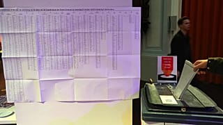 Un uomo esprime il proprio voto accanto a una lista di candidati su una scheda elettorale nella chiesa De Duif di Amsterdam, 29 ottobre 2025