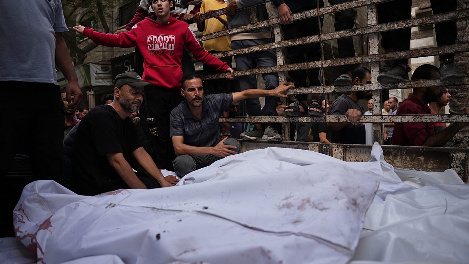 فلسطينيون يحيطون بجثامين عائلة أبو دلال التي قُتلت في غارة إسرائيلية، خلال جنازتهم في مستشفى العودة بمخيم النصيرات وسط قطاع غزة، الأربعاء 29 تشرين الأول/أكتوبر 2025. 