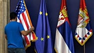 A protocol staff member arranges US, EU and Serbian flags in Belgrade, Serbia.