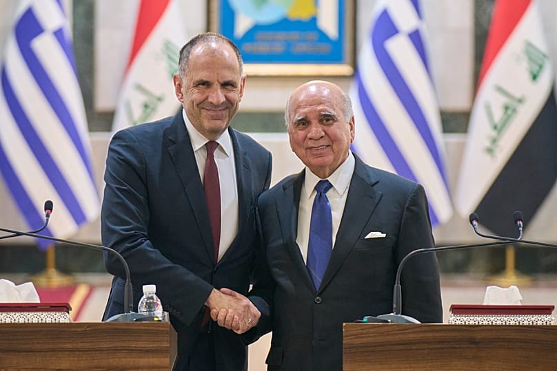 Iraqi Foreign Minister Fuad Hussein shakes hands with his Greek counterpart George Gerapetritis in Baghdad, 30 October, 2025