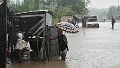 Moradores caminham por uma rua inundada após a passagem do furacão Melissa em Petit-Goave, Haiti
