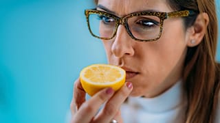 امرأة تحاول استنشاق رائحة الليمون.