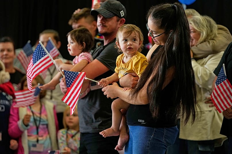 Afrikaner refugees from South Africa holding American flags arrive at Dulles International Airport, 12 May, 2025