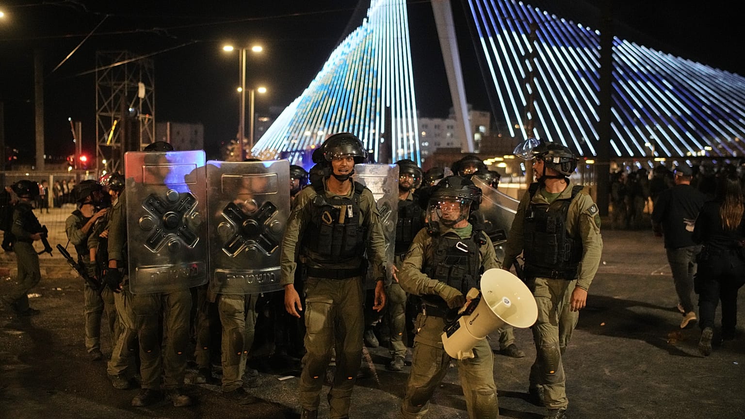 Israeli police officers disperse ultra-Orthodox Jewish men blocking a road during a protest against plans to require them to serve in the Israeli military, in Jerusalem