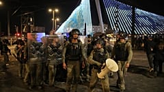 Израильские полицейские разгоняют ультраортодоксальных иудеев, перекрывших дорогу во время акции протеста против планов обязать их служить в израильской армии, в Иерусалиме.