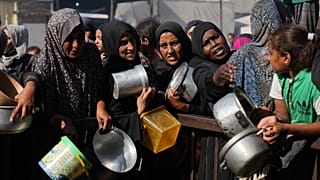 فلسطينيون ينتظرون الحصول على تبرعات من السكر والأرز بمدينة خان يونس جنوب قطاع غزة، الجمعة 31 تشرين الأول/أكتوبر 2025. 