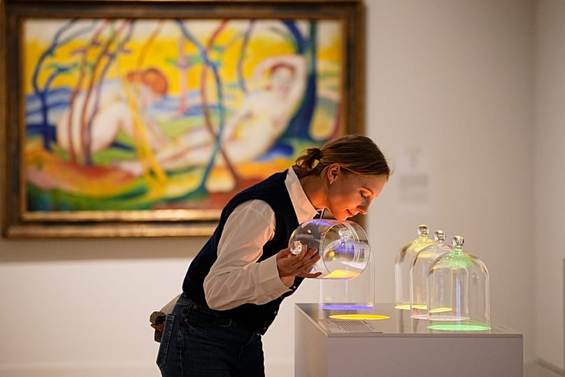 A woman smells samples of different lights during the exhibition "The Secret Power of Scents"