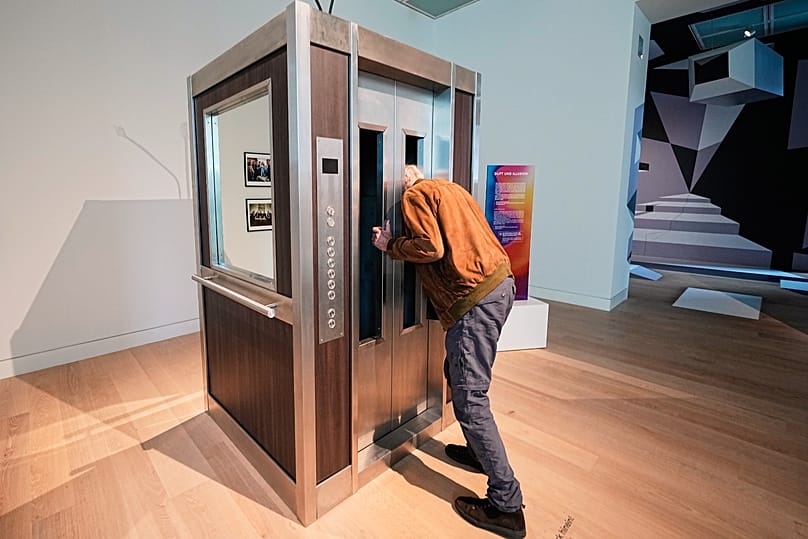 A man puts his head into an elevator where he smells a scent based on samples that NASA collected at space