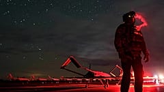 Украинский командир смотрит в очки ночного видения перед взлетом беспилотника в неустановленном месте в Украине, 14 октября 2025 г.