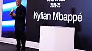 Real Madrid's Kylian Mbappe poses to the media after receiving the Golden Boot award during a ceremony in Madrid