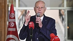 الرئيس التونسي قيس سعيد يلوح لمواطني تونس أثناء إلقائه خطابًا خلال زيارته إلى مدينة سيدي بوزيد، تونس (سليم عبيد/الرئاسة التونسية عبر أسوشيتد برس)