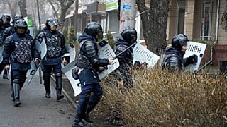 Полицейские блокируют демонстрантов во время акции протеста в Алматы, 5 января 2022 года.