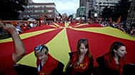 FILE: Supporters of the ruling coalition wave national and party flags, during a rally in front of the Parliament building in Skopje, 18 May 2015