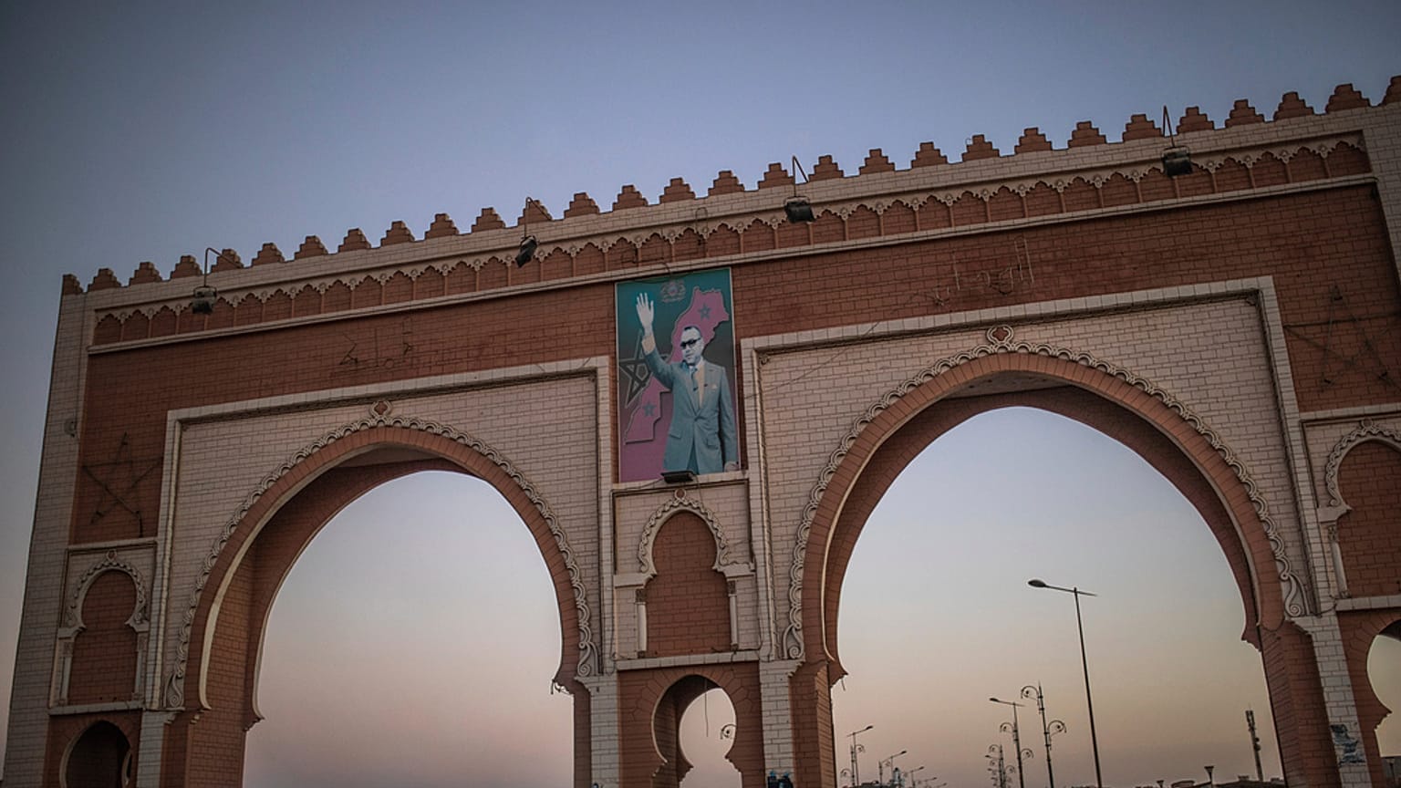 ARQUIVO: Um arco na entrada de Dakhla ostenta uma imagem do rei Mohammed VI de Marrocos, no Sahara Ocidental, a 21 de dezembro de 2020.
