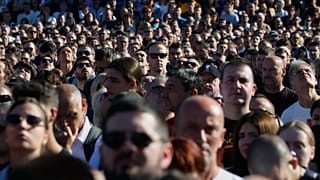 Des personnes observent 16 minutes de silence en mémoire des victimes, devant la gare, à l'occasion du premier anniversaire de la catastrophe qui a coûté la vie à 16 personnes