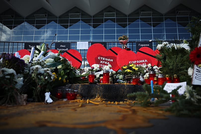 Des bougies et des fleurs sont déposées devant la gare de Novi Sad, en Serbie, le samedi 1er novembre 2025, à l'occasion du premier anniversaire de la catastrophe