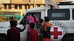 Fahrzeuge des Roten Kreuzes tragen die Leichen von zwei Menschen