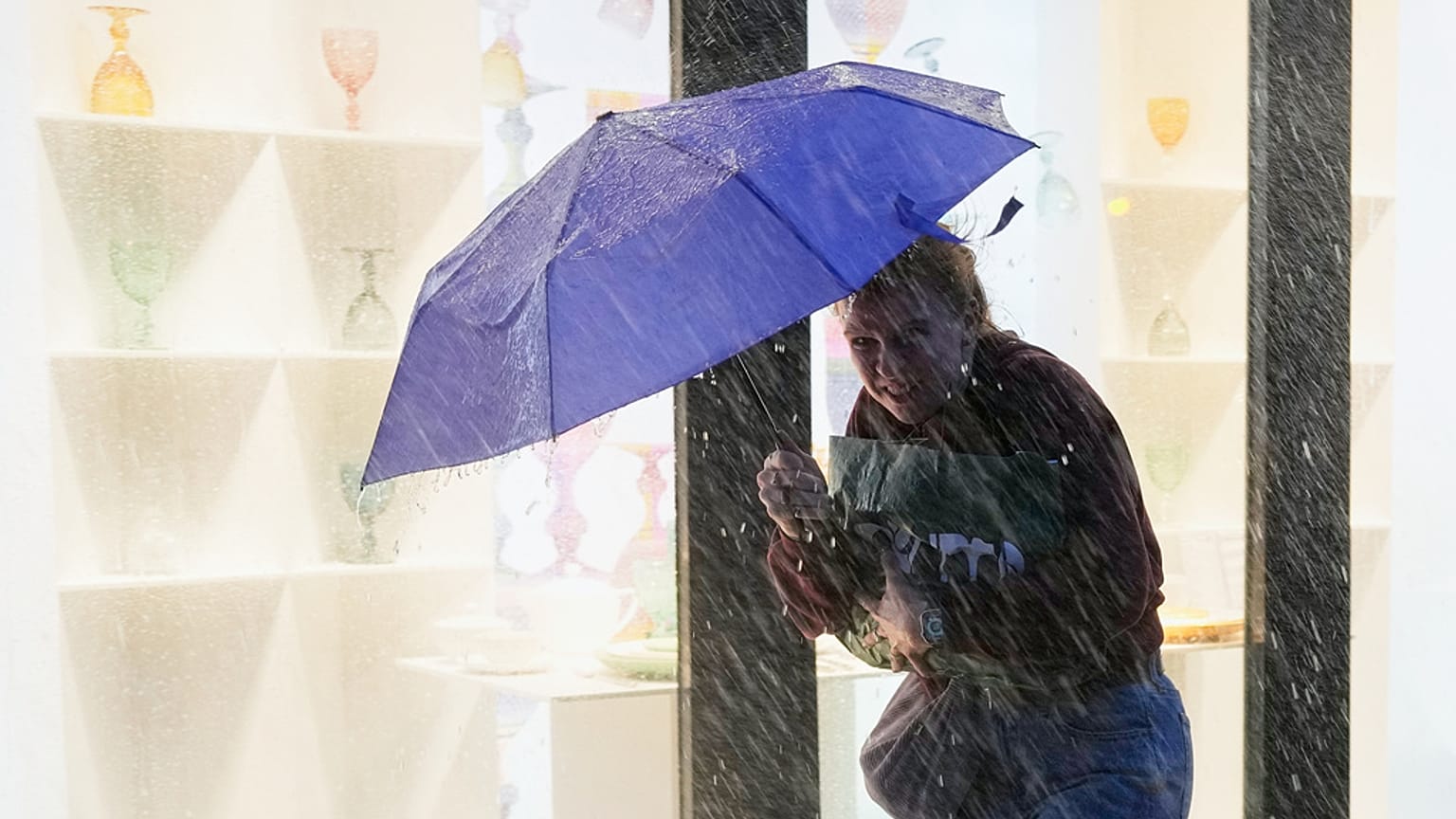 Una mujer sostiene su paraguas contra el viento durante una fuerte lluvia en el centro de Lisboa, el martes 28 de octubre de 2025.