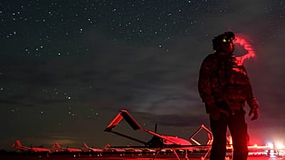 A Ukrainian soldier looks through night vision goggles before An-196 Liutyi long-range drones take off towards Russia; Ukraine, 14 October 2025